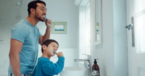 father and son brushing teeth preventing tooth decay
